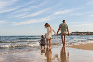 Familie mit Kind beim gemeinsamen Spaziergang am Strand